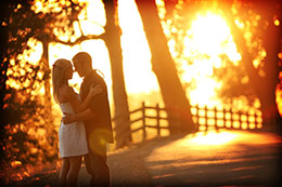 Engaged couple along a roadside with firery sunset