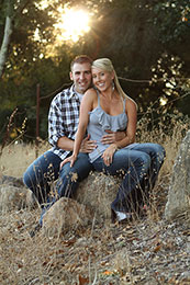 Engaged couple pose along roadside in sunset near Santa Rosa winery